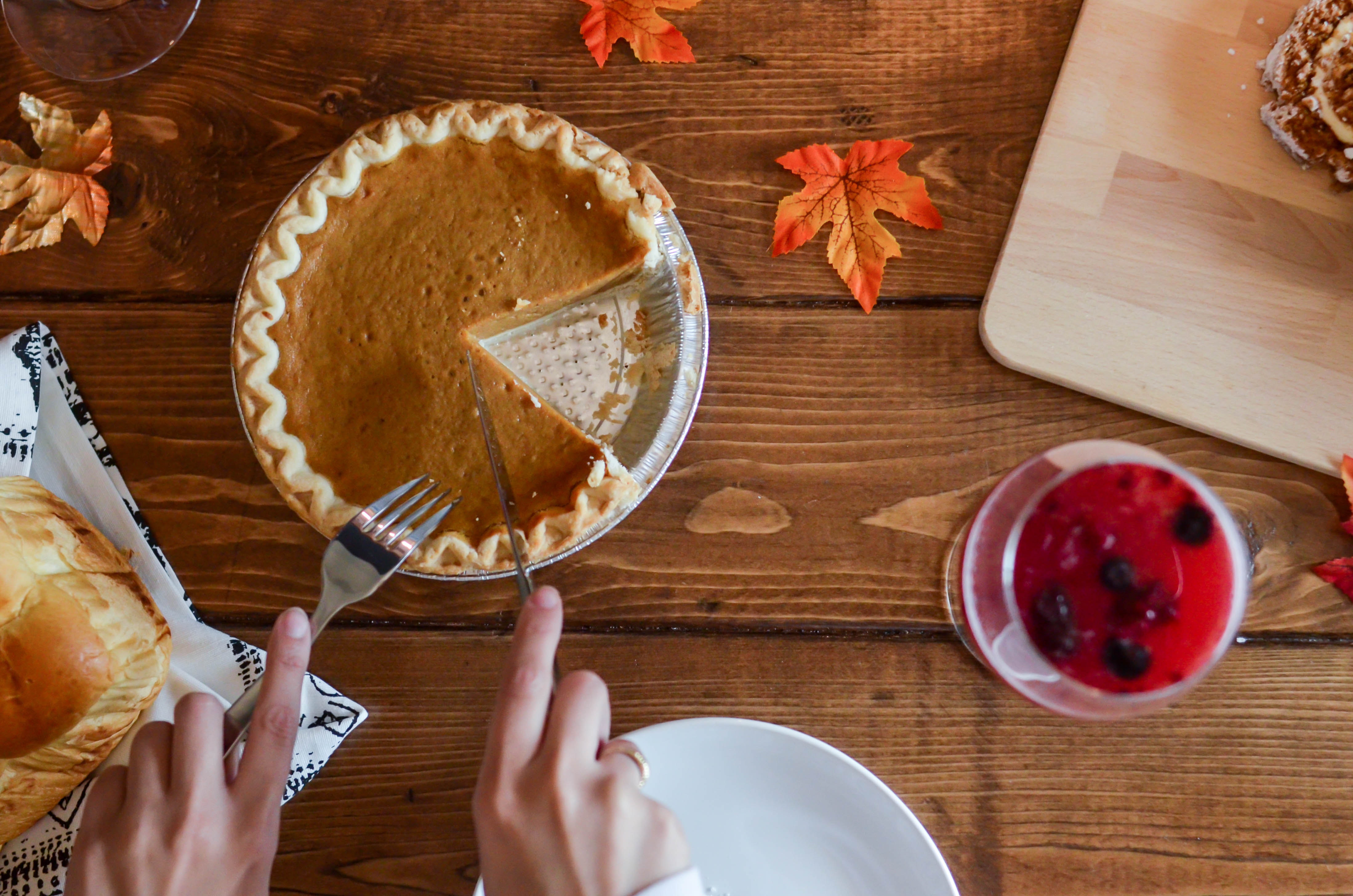 person-holding-knife-and-fork-cutting-slice-of-pie-on-brown-669734.jpg