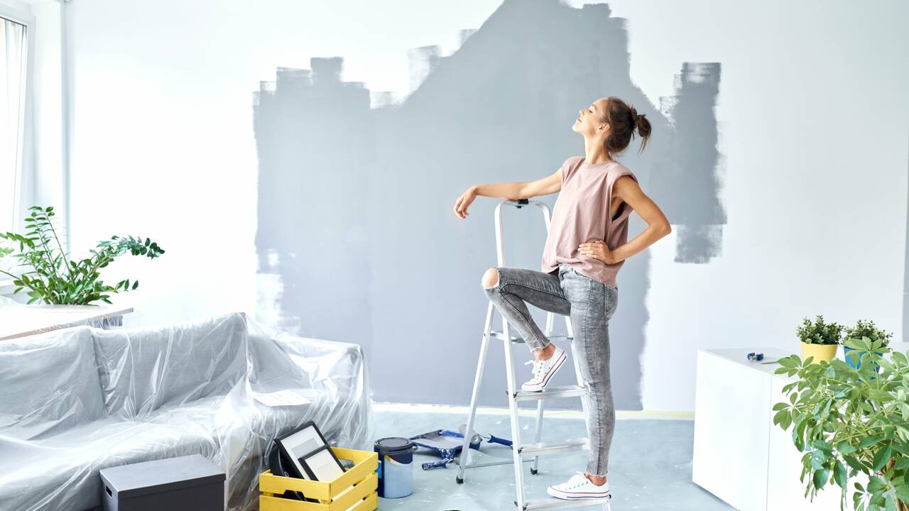woman-standing-ladder-half-painted-wall.jpg