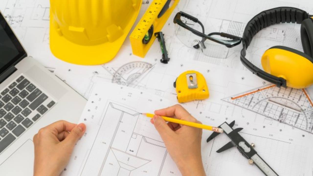 hand-over-construction-plans-with-yellow-helmet-and-drawing-tool_1232-2909.jpg