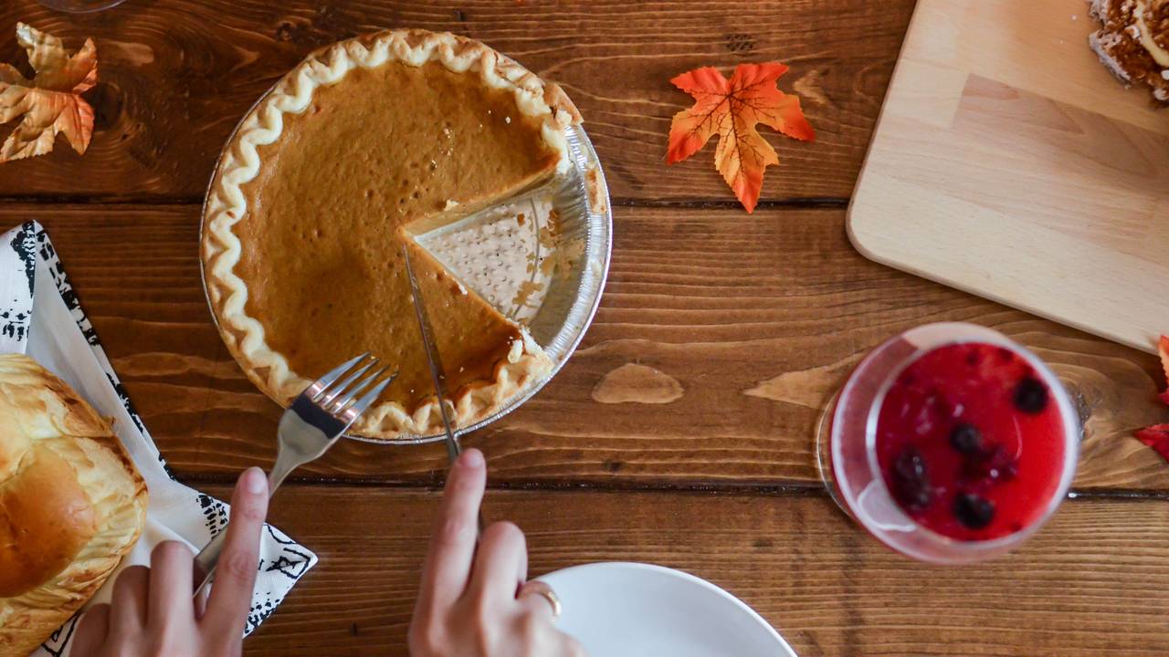 person-holding-knife-and-fork-cutting-slice-of-pie-on-brown-669734.jpg
