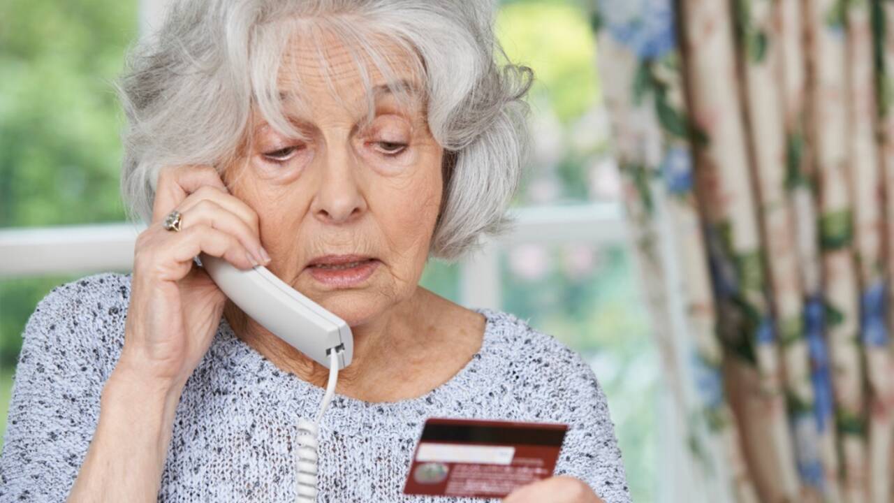 senior-woman-giving-credit-card-details-on-the-phone-picture-id481119988.jpg