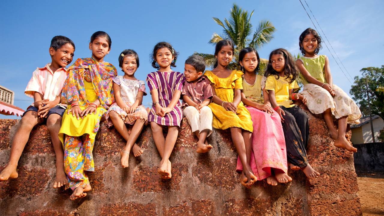 iStock-cheerful_Indian_children_sitting_on_a_wall.jpg